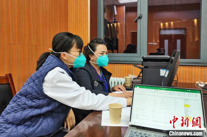 8月9日，楊蘇喬(左)在拉薩方艙醫(yī)院指揮部讀取艙內(nèi)患者胸部CT?！∈茉L者供圖