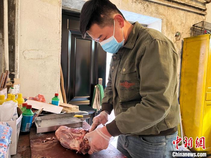 圖為雪豹“奶爸”史壽軍正在準(zhǔn)備投喂雪豹的食材?！●R銘言 攝