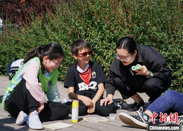 圖為小朋友在青海西寧湟水國家濕地公園內(nèi)認識植物并進行繪畫。　馬銘言 攝