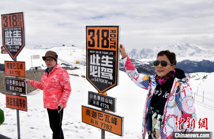 圖為5月14日，西藏林芝色季拉山觀景臺(tái)，游客與南迦巴瓦峰合影?！±盍?攝