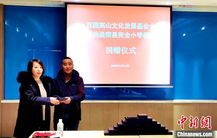 圖為西藏高山文化發(fā)展基金會理事長溫麗向聶榮縣完全小學負責人捐助儀器?！∮谫e 攝