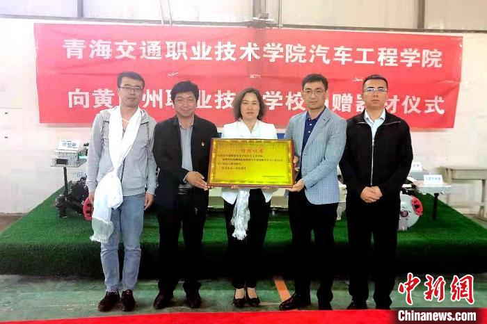 圖為李富香(中)代表學(xué)校為州縣技校捐贈(zèng)器材。(資料圖) 青海省教育廳供圖