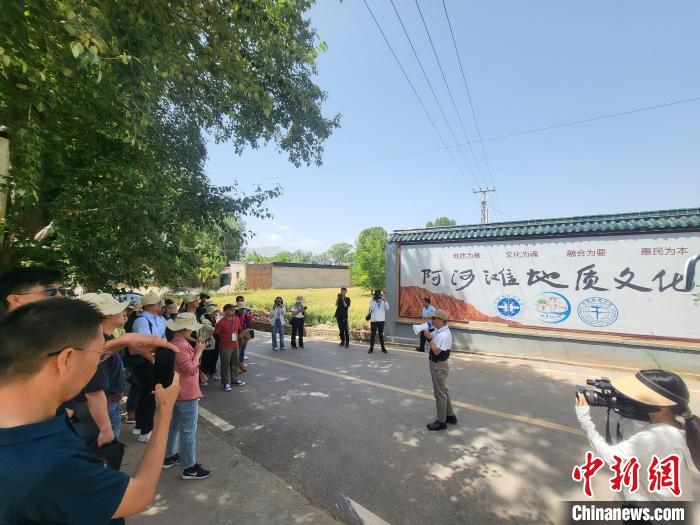 圖為中國地質(zhì)大學(xué)(北京)教授張緒教介紹村落情況。　胡友軍 攝