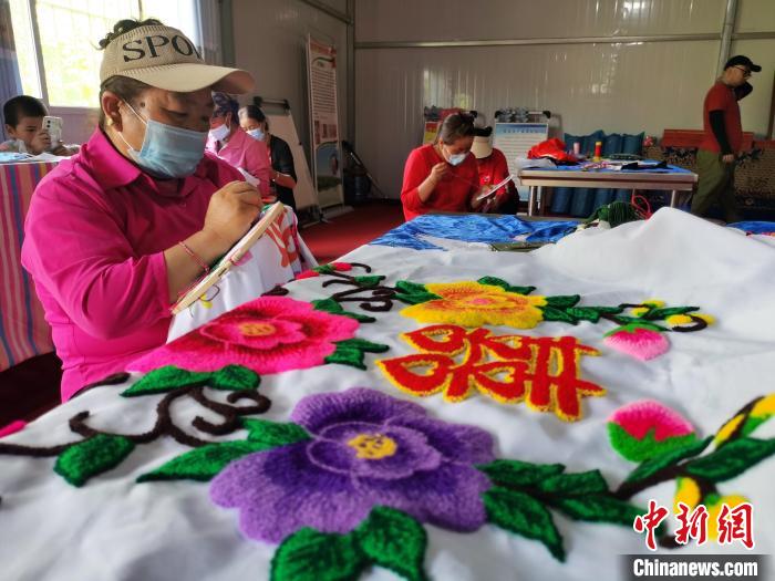 圖為婦女制作青繡?！?zhí)砀?攝