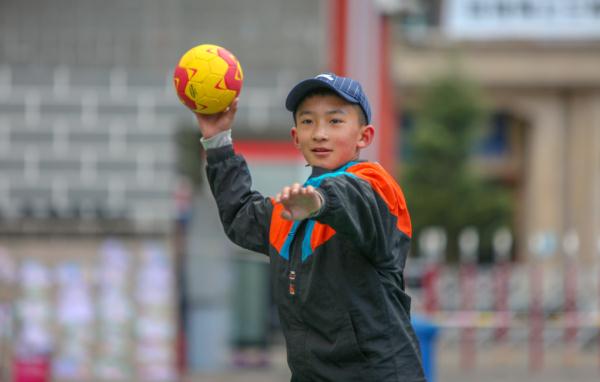 在高原上教孩子們打手球，“慢慢兒來，甭著急！”