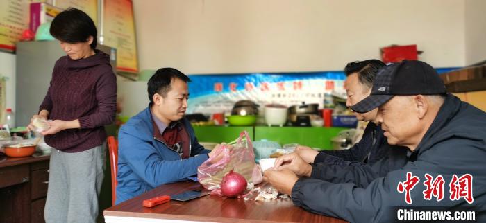 圖為扶貧路上“臨時(shí)一家人”準(zhǔn)備午餐?！∥航ㄜ?攝