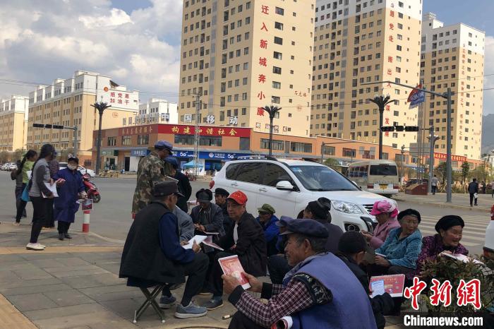 圖為會(huì)澤縣城易地扶貧搬遷安置點(diǎn)內(nèi)，老人們聚在廣場上聊天，身后是他們的新家?！】姵?攝