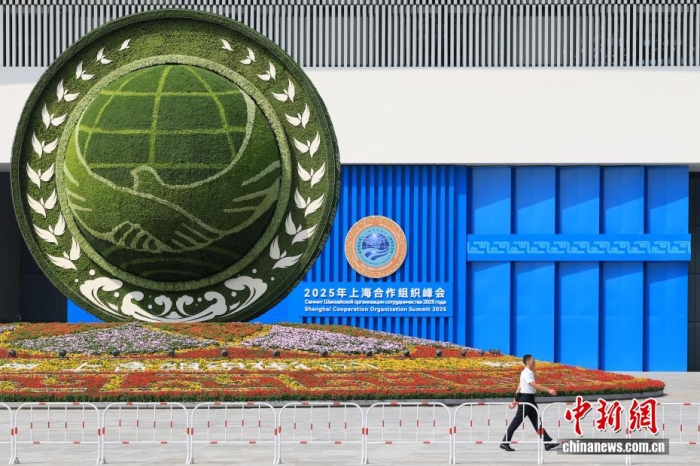 8月31日，天津，一名工作人員從2025年上海合作組織峰會(huì)主會(huì)場外的景觀花壇旁經(jīng)過。當(dāng)日，2025年上海合作組織峰會(huì)在天津舉行。<a target='_blank' href='/'><p  align=