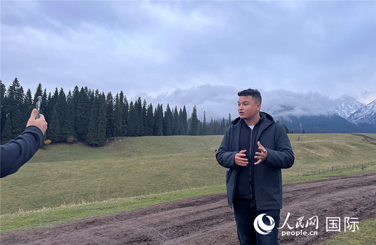 在庫爾德寧，吾買爾江被雪山美景震撼，即興錄制了短視頻作品。人民網(wǎng)記者曾書柔攝