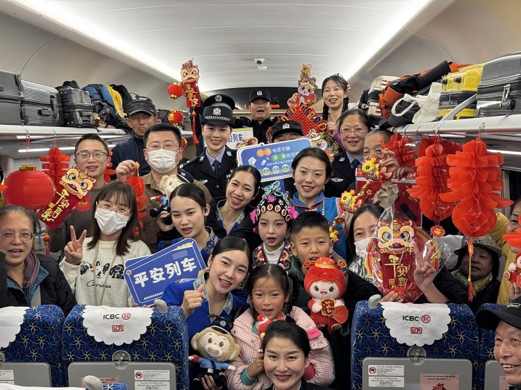 春節(jié)期間，在中老鐵路磨萬（磨丁—萬象）段，鐵路客運員工與乘客合影留念。李加勇攝