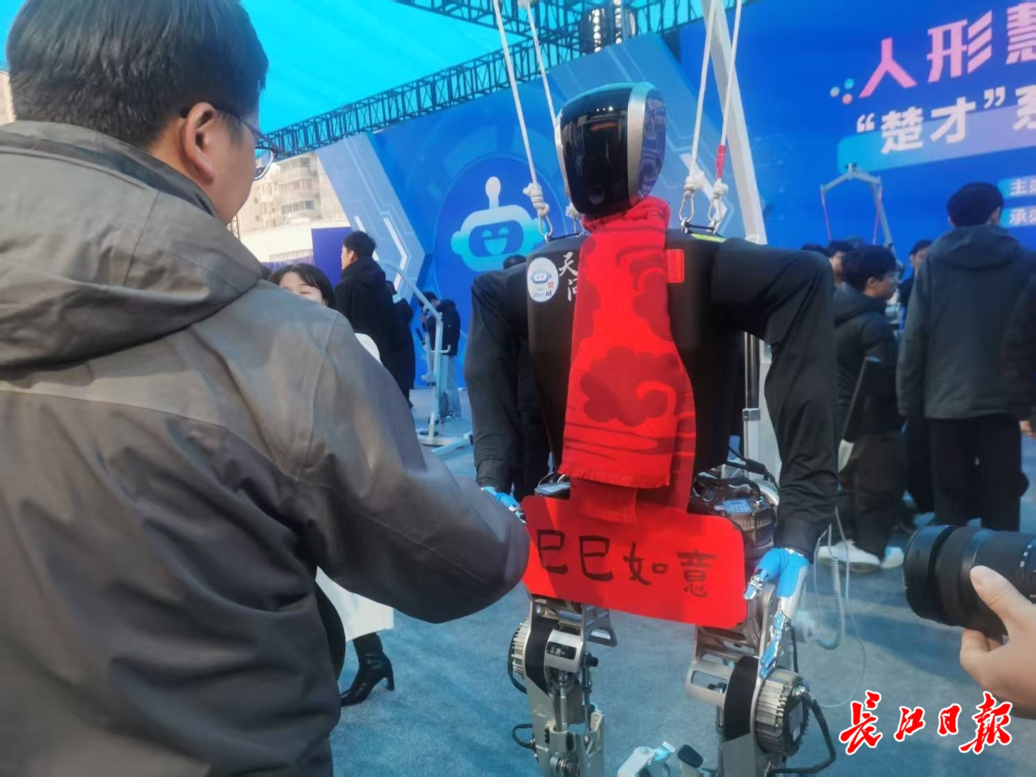 “天問”人形機(jī)器人和參觀市民握手，互致新年快樂。 長江日報(bào)記者陳永權(quán) 攝