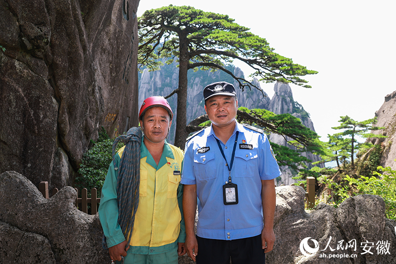 全國道德模范李培生（左）和胡曉春在迎客松前合影。人民網(wǎng)記者 張俊攝