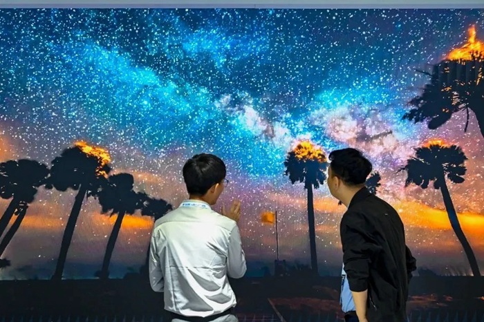 長春光博會(huì)希達(dá)電子展區(qū)，一位工作人員正在給一位觀眾講解。（長春新區(qū)供圖）