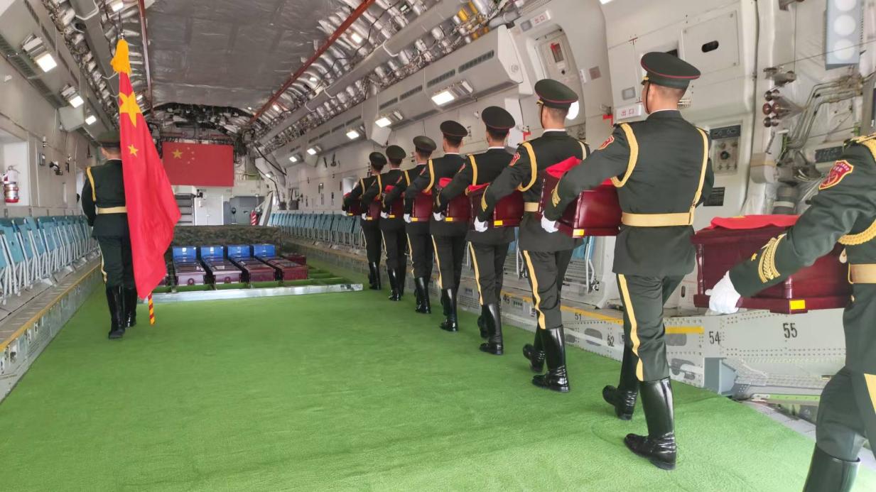 在韓國仁川國際機(jī)場，引靈手徐澤東引領(lǐng)中國人民解放軍儀仗司禮大隊(duì)禮兵護(hù)送英烈遺骸棺槨登上空軍“運(yùn)-20”專機(jī)啟程回國?？照麄骶止﹫D