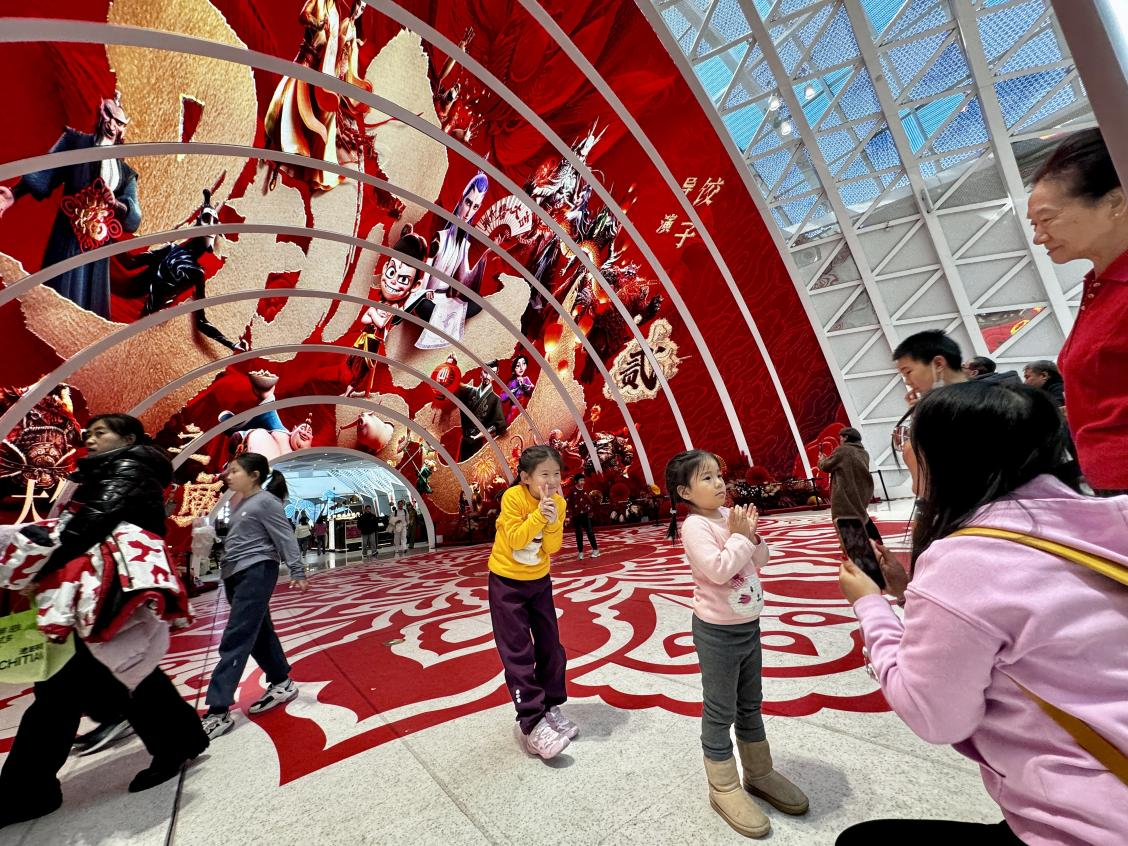 乙巳蛇年春節(jié)期間，影迷在《哪吒之魔童鬧?！肪薹?bào)前拍照打卡。