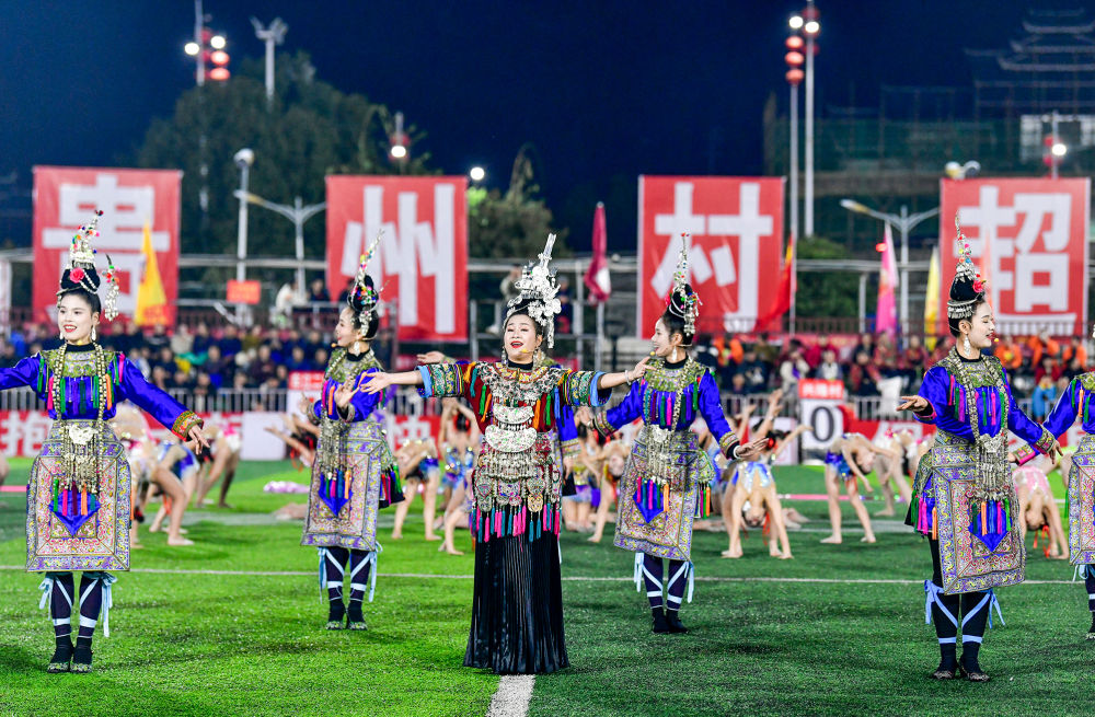 2025年3月14日，2025年貴州“村超”40強交叉賽在榕江“村超”足球場舉行，演員在比賽間隙表演侗族大歌，民族文化伴隨著體育賽事成功“出圈”。圖片來源：新華社