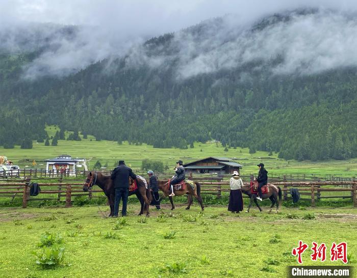 6月10日，游客在魯朗小鎮(zhèn)高山牧場景區(qū)體驗(yàn)騎馬。　冉文娟 攝