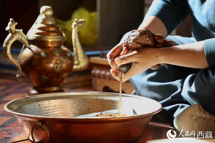 牛角鉆孔，將木泥擠出。人民網(wǎng)記者 次仁羅布攝