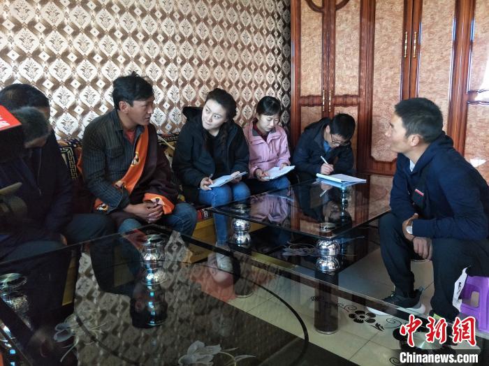 圖為調(diào)查組工作人員正在入戶調(diào)查?！∑钤鲚?攝