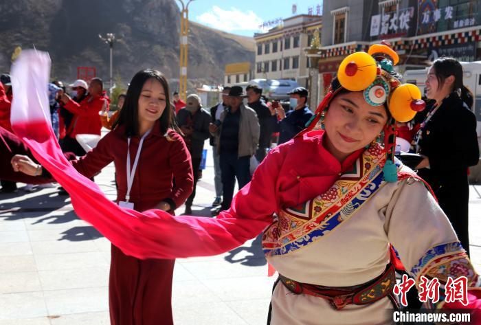 圖為中外記者向當?shù)孛癖妼W習民族歌舞文化。　張?zhí)砀?攝