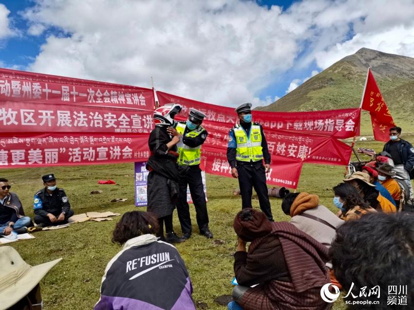 給牧民講如何佩戴安全頭盔。巴登攝