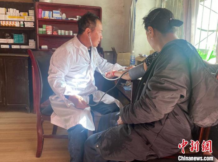 索木滾(左)為村民看病?！∪捞量h委宣傳部供圖