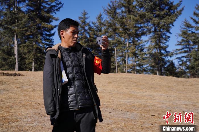 圖為桑杰加進(jìn)行巡查并拍照記錄?！●R銘言 攝