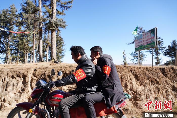 圖為同事騎摩托車載著桑杰加(后)前往林場(chǎng)?！●R銘言 攝