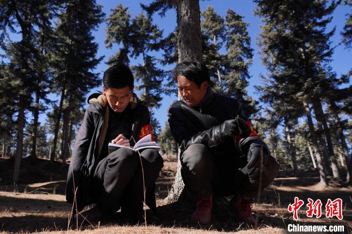 圖為桑杰加(左)和同事記錄巡查結(jié)果?！●R銘言 攝