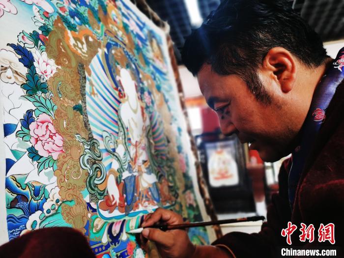 圖為久美尖措創(chuàng)作唐卡?！?zhí)砀?攝