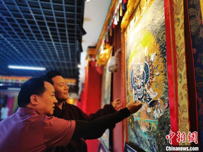 圖為久美尖措展示唐卡作品。　張?zhí)砀?攝