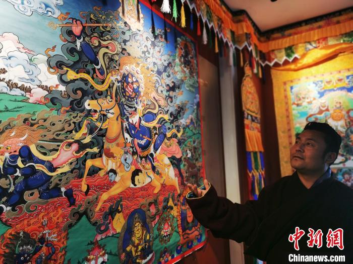 圖為久美尖措展示唐卡作品。　張?zhí)砀?攝