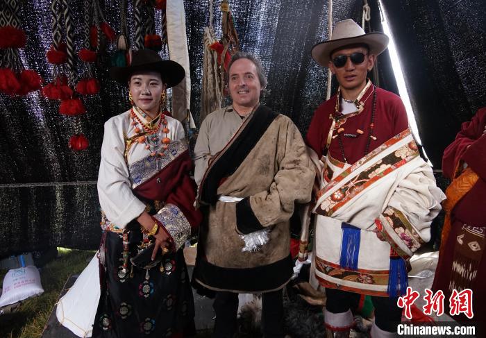 圖為一名外籍?dāng)z影師(中)身穿藏服和藏族民眾合影留念?！●R銘言 攝