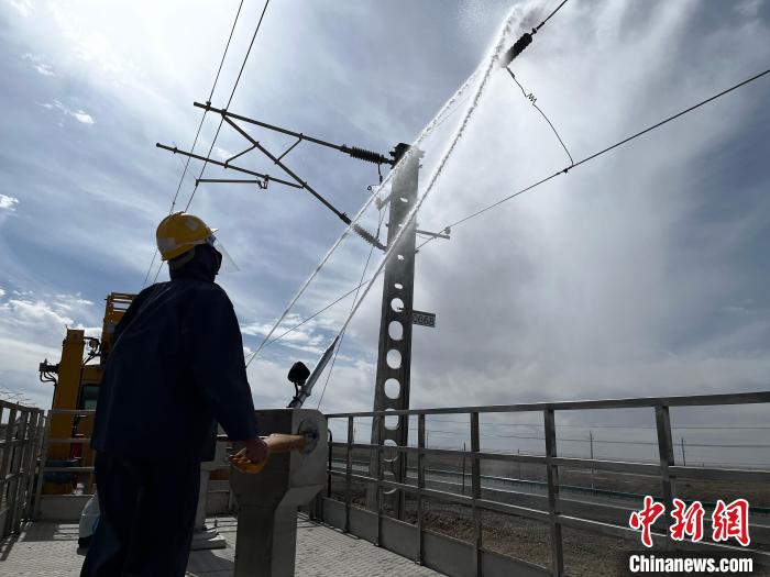 圖為高壓水槍的水柱沖洗絕緣子串。　高啟宏 攝