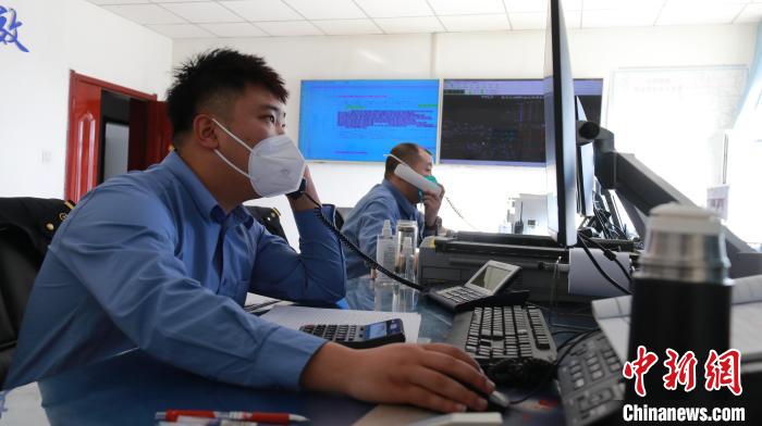 圖為貨運(yùn)調(diào)度人員與外勤工作人員聯(lián)系掌握車輛裝載情況?！±钌?攝