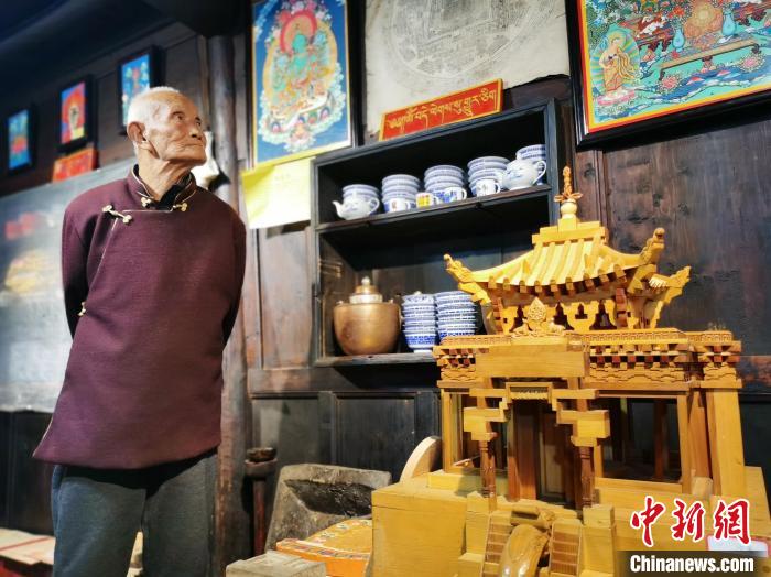 圖為古堡內(nèi)的藝人桑杰展示自己的雕刻作品?！?zhí)砀?攝