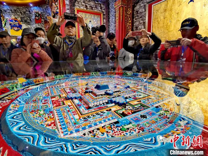 圖為參觀者拍攝壇城?！?zhí)砀?攝