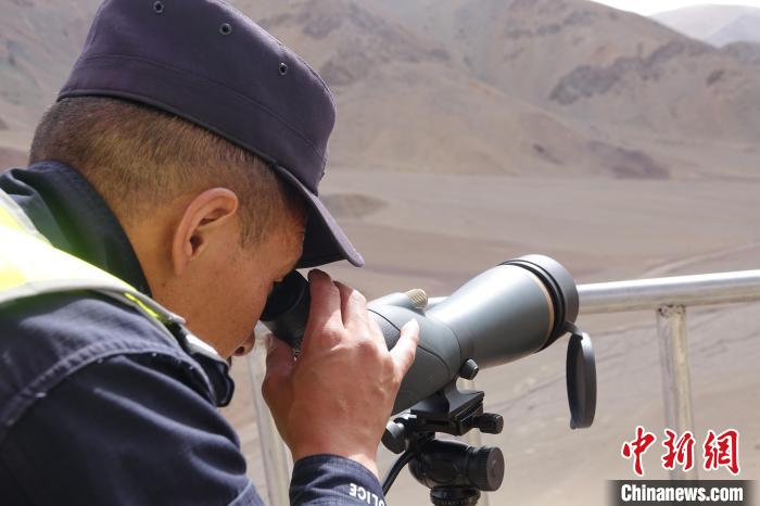 索朗曲扎用望遠鏡查看邊境情況。　冉文娟 攝