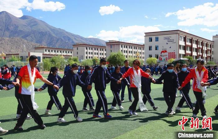 圖為世界冠軍與拉薩阿里地區(qū)高級中學學生一起跳鍋莊?！∪轿木?攝