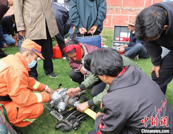 圖為森林消防員為護林員講解滅火裝備的使用方法。　昌都市森林消防支隊 供圖