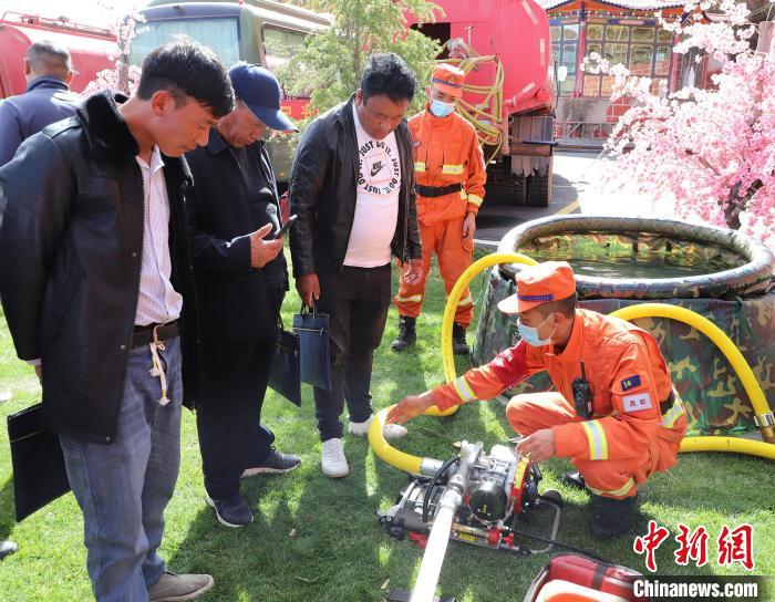 圖為森林消防員為護林員講解滅火裝備的使用方法?！〔际猩窒乐ш?供圖