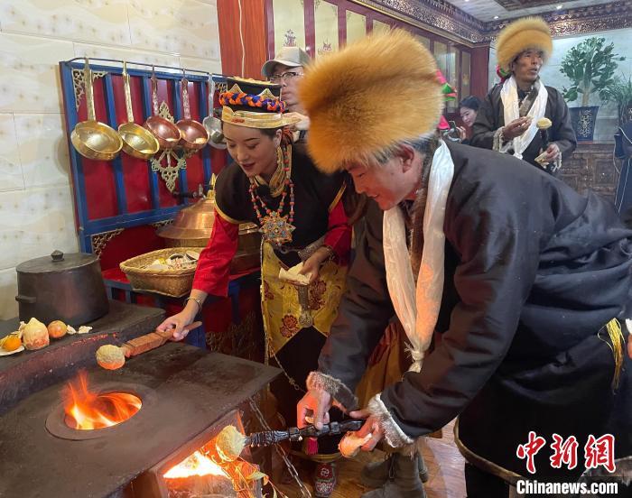 圖為人們?cè)诨鹕峡竟?jié)日美食“結(jié)達(dá)”?！∪轿木?攝