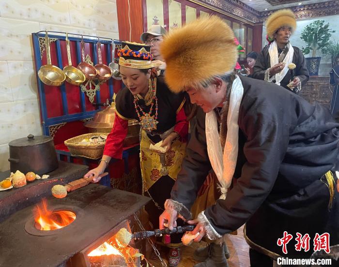 圖為人們?cè)诨鹕峡竟?jié)日美食“結(jié)達(dá)”?！∪轿木?攝