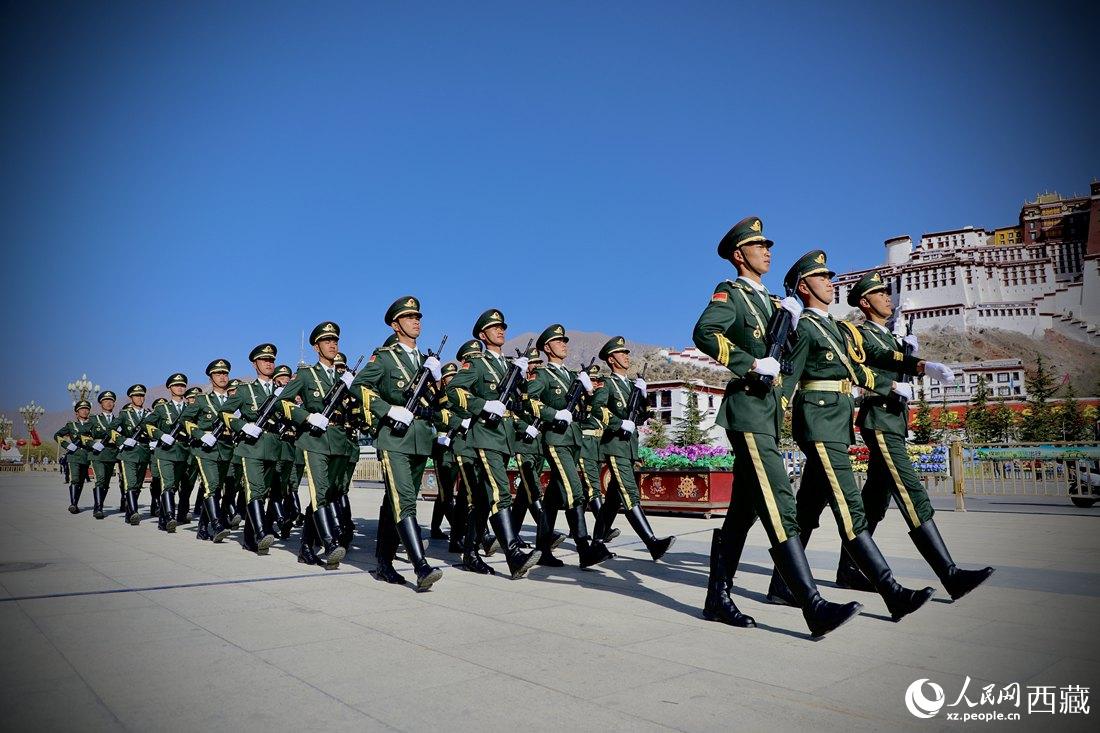 國(guó)旗護(hù)衛(wèi)隊(duì)隊(duì)員緊握鋼槍，踏著威武雄壯的步伐，走向國(guó)旗臺(tái)。人民網(wǎng) 次仁羅布攝