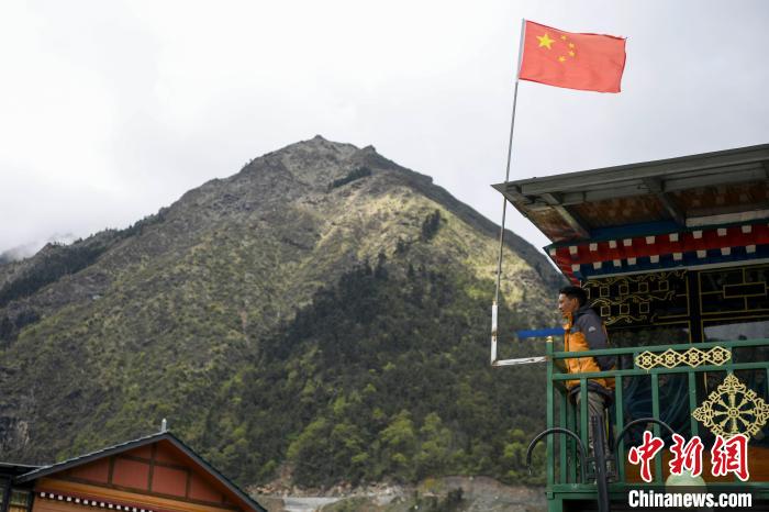 村民站在樓房上觀望。　楊華峰 攝