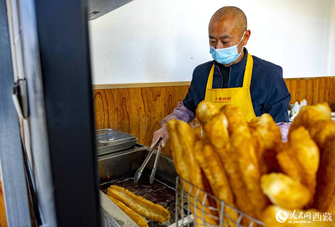 早餐店老板正在炸油條。人民網(wǎng) 次仁羅布攝
