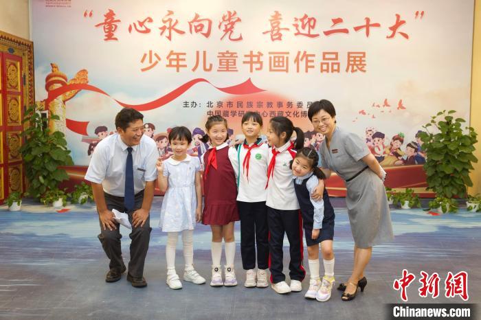 圖為與會(huì)嘉賓與入選畫(huà)作的“小作者”們?cè)谡褂[上合影?！≈袊?guó)藏學(xué)研究中心供圖