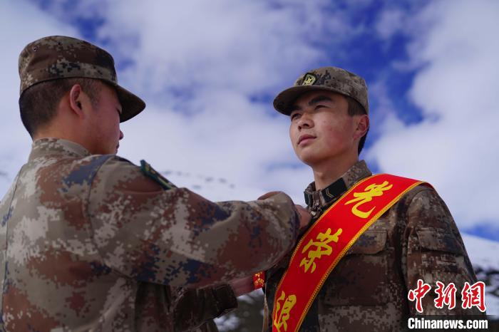 排長(zhǎng)王朝偉(圖左)給退伍老兵佩戴大紅花?！∥鞑厣侥宪姺謪^(qū)某團(tuán)供圖