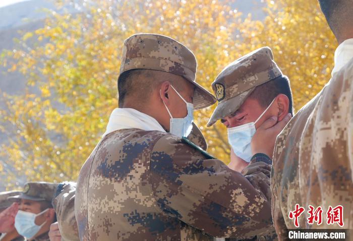 圖為什布奇邊防連退伍老兵與戰(zhàn)友相擁而泣，依依惜別?！⌒觳?攝