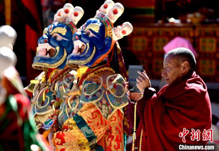 2月19日，正在拍攝跳神活動(dòng)的僧人?！±盍?攝